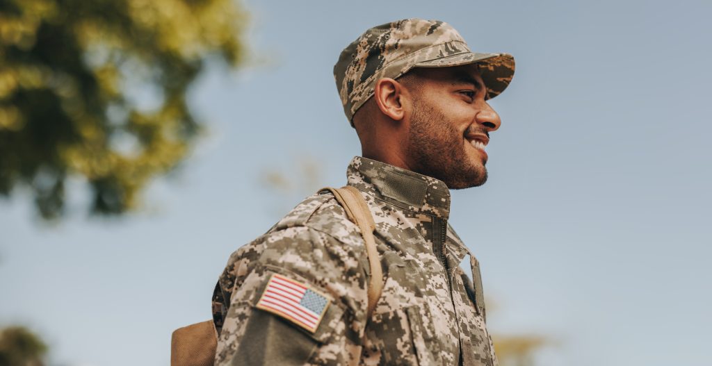 Young American soldier representing the military standing and smiling from side angle.