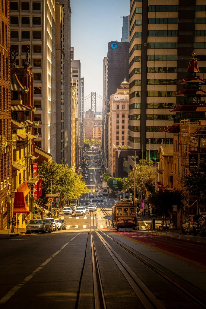 A scenic view of San Francisco, featuring the iconic Golden Gate Bridge with cars traveling across, highlighting the city skyline in the background, perfect for showcasing auto shipping services.