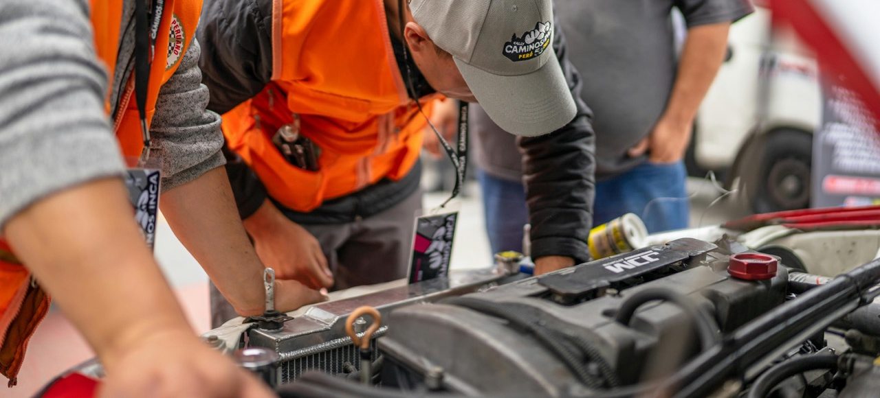 Auto repairmen checking a car before car shipping.
