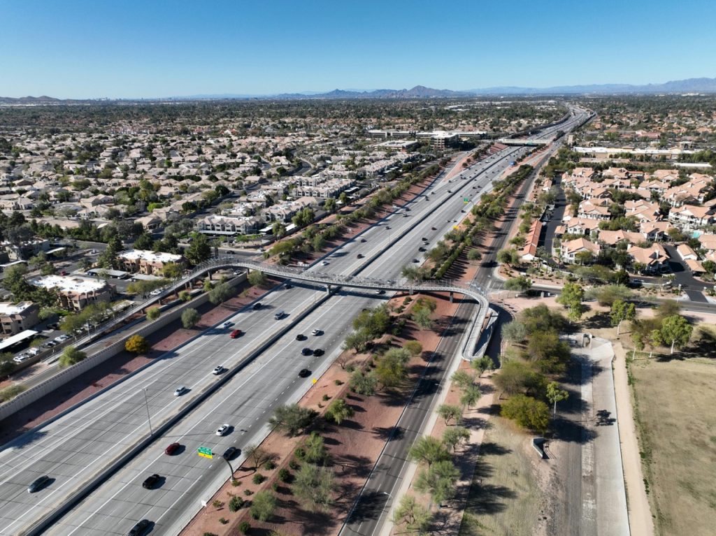 Arizona highway with multiple lanes, cars, and semi trucks; perfect for car shipping and auto transport.