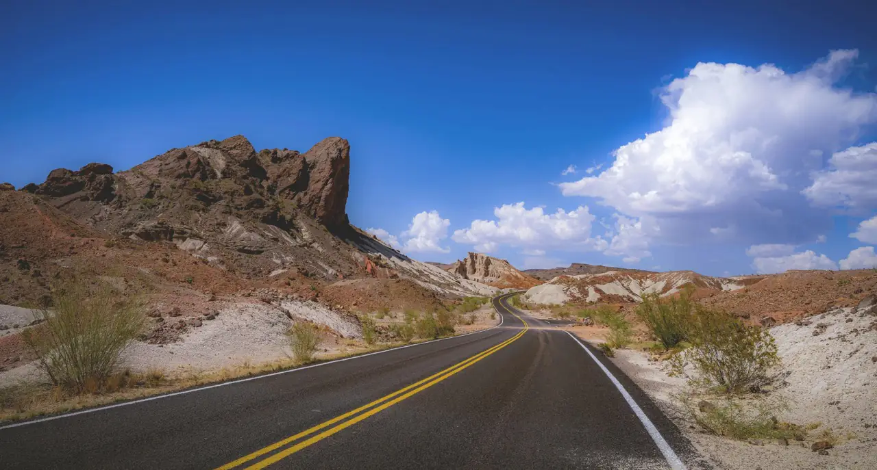 Open freeway in Texas with surrounding desert and mountains, typical road for car shipping.