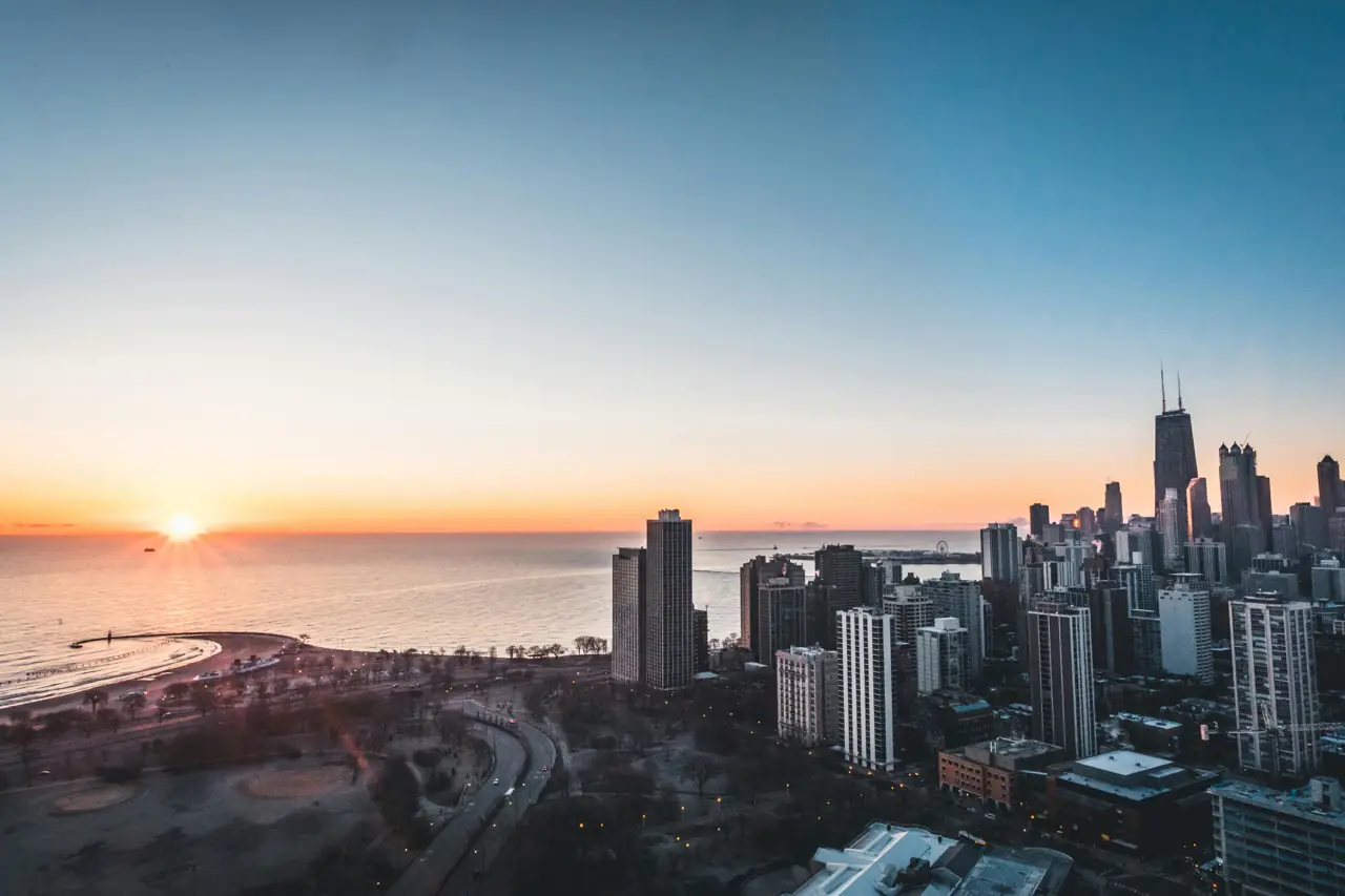 Sunsetting behind Chicago skyline and Illinois freeway, Illinois car shipping on the road.